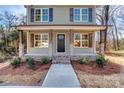 Inviting front porch with wood posts and brick steps leading to the entrance at 277 Stewart Nw St, Concord, NC 28027