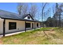 Side view of house showcasing white siding and black trim against a wooded backdrop at 3720 Turner Rd, Clover, SC 29710