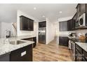 Spacious kitchen boasts stainless steel appliances, granite counters, dark cabinets, and wood floors at 159 Charles Farm Dr, Cleveland, NC 27013