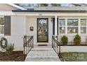 Newly renovated front entry with glass door and metal railings at 1814 Archdale Dr, Charlotte, NC 28210