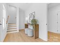 Bright entryway featuring light wood floors, stairs, a table, decor, and stools at 3705 Lou Ann Ave, Charlotte, NC 28208