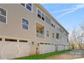 Side view of three story townhome with attached garage and small lawn at 3709 Lou Ann Ave, Charlotte, NC 28208