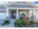 Inviting front porch with stone columns and landscaping at 5158 Turtle Creek Dr, Denver, NC 28037