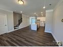 Inviting living space with luxury vinyl plank flooring, open staircase, and an open layout to the modern kitchen at 5552 Stafford Rd # 28, Charlotte, NC 28215