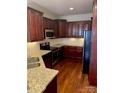 Kitchen featuring cherry cabinets, granite counters, and stainless steel appliances at 6605 Central Pacific Ave, Charlotte, NC 28210