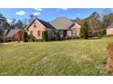 Landscaped lawn and brick home with driveway at 7757 St Andrews Ln, Stanley, NC 28164