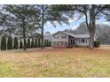 A home with a spacious front yard featuring mature trees and lush greenery at 939 Malotte Ln, Gastonia, NC 28054