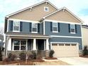 Two-story home with blue and beige siding, a two-car garage and landscaping at 9831 Quercus Ln, Huntersville, NC 28078