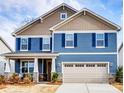 Charming two-story home featuring blue siding, tan accents, and a welcoming front porch with a two car garage at 9831 Quercus Ln, Huntersville, NC 28078