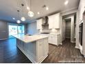 An open-concept kitchen with white cabinets, island seating, and stainless steel appliances at 9831 Quercus Ln, Huntersville, NC 28078