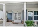 White double front doors with sidelights, stone base, and covered porch at 11112 Benjamin Smith Ave, Huntersville, NC 28078