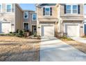 Tan three-story townhome with two-car garage and landscaping at 18106 Pear Hawthorne Dr, Huntersville, NC 28078
