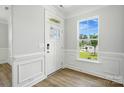 Bright entryway featuring paneled walls, wood floors, and natural light at 2024 Embassy Ct # 49, Charlotte, NC 28213