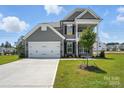 Gray two-story home featuring a well-maintained lawn and attached two-car garage at 2024 Embassy Ct # 49, Charlotte, NC 28213