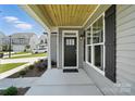 Welcoming front porch with wood ceiling and modern black front door at 2024 Embassy Ct # 49, Charlotte, NC 28213