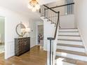 Bright entry with hardwood floors, staircase, and decorative console table at 5222 Winding Brook Rd, Charlotte, NC 28226