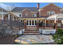 Brick home with spacious deck, stone patio, pergola, and steps leading to the yard at 5401 Sunningdale Dr, Charlotte, NC 28277