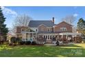 Home's back view, showcasing a deck, screened porch, and yard at 5401 Sunningdale Dr, Charlotte, NC 28277