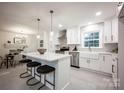 Bright kitchen with a center island, bar stool seating, stainless steel appliances, and a modern farmhouse sink at 7001 Starvalley Dr, Charlotte, NC 28210