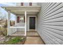 Charming front entrance with a black front door, white porch, and decorative landscaping at 8702 Wood Sorrel Ct, Matthews, NC 28105