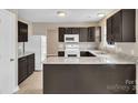Features granite counters, stainless steel sink, white appliances, and dark wood cabinets at 8702 Wood Sorrel Ct, Matthews, NC 28105