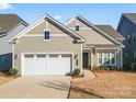 Tan two-story house with white garage door and landscaping at 1025 Lake Como Dr, Monroe, NC 28110