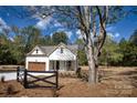 View of charming home surrounded by lush trees and landscaping, accented by a rustic fence at 1037 Oakmont Dr, Rock Hill, SC 29732