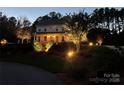 Two-story home with front porch and beautiful landscape lighting at night at 116 Cedar Branch Ct, Mooresville, NC 28117