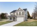 Attractive two-story home featuring gray siding, a welcoming front porch and an attached two-car garage at 1305 39Th Avenue Ne Pl, Hickory, NC 28601