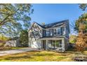 Two-story home with gray siding, blue shutters, and a long driveway at 1305 39Th Avenue Nw Pl, Hickory, NC 28601