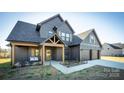 Two-story farmhouse with gray siding, two-car garage, and covered porch at 187 Lone Pine Rd, Statesville, NC 28625