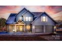 Two-story farmhouse with gray siding, two-car garage, and covered porch at dusk at 187 Lone Pine Rd, Statesville, NC 28625