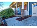 Front porch with stone columns and charming landscaping at 4418 Huntley Glen Dr, Pineville, NC 28134