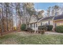 Tan house with white door, landscaping, and black shutters at 9325 Four Mile Creek Rd, Charlotte, NC 28277