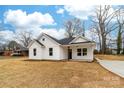 Beautiful white home featuring dark trim, a manicured lawn, and a welcoming front porch at 1200-1 Stanton Dr, Shelby, NC