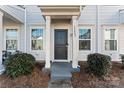 Townhome entrance with dark gray door, white columns, and walkway at 13883 Clayborn St, Midland, NC 28107