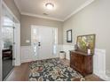 Bright entryway with hardwood floors, white wainscoting, and a wooden console table at 19914 Wooden Tee Dr, Davidson, NC 28036