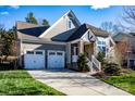 Gray two-story house with stone accents, two-car garage, and landscaped yard at 19914 Wooden Tee Dr, Davidson, NC 28036