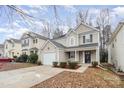 Beige two-story house with a white garage door, landscaping, and a view of neighboring homes at 2604 Cochrane Dr, Charlotte, NC 28269