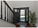 Bright entryway with black staircase, wood floors, and view to the front door at 373 Battery Cir, Clover, SC 29710