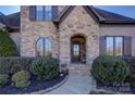 Elegant front entrance with stone detailing and a charming walkway at 4010 Soleado Dr, Matthews, NC 28104