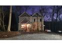 Evening view of two-story home with stone and wood siding, well-lit entrance at 600 E Monbo Rd, Statesville, NC 28677