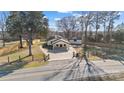 Aerial view of a beautiful single-story home with mature trees and a long driveway at 6211 Rock Island Rd, Charlotte, NC 28278