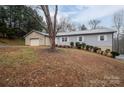 Gray siding ranch home with a large tree in the front yard and an attached garage at 7704 Woodland Hills Rd, Hickory, NC 28602