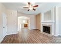 Living room with hardwood floors, fireplace, and kitchen view at 13441 Calloway Glen Dr, Charlotte, NC 28273