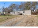 Lovely one-story home with gray siding, black shutters, and large grassy front yard and a dirt driveway at 1805 Drew Dr, Lincolnton, NC 28092