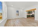 Bright, open living room with wood-look floors and a view into the kitchen with green cabinets at 210 S Millon St, Gastonia, NC 28052