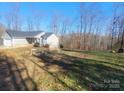 House on a lot with large trees and a sloped yard at 34466 Lisa Dr, Albemarle, NC 28001