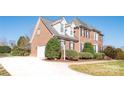 Brick home with a white garage door and well-maintained landscaping at 5023 Ancestry Cir, Matthews, NC 28104