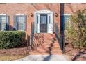 Brick front entry with a dark door, white trim, and black railings at 5023 Ancestry Cir, Matthews, NC 28104